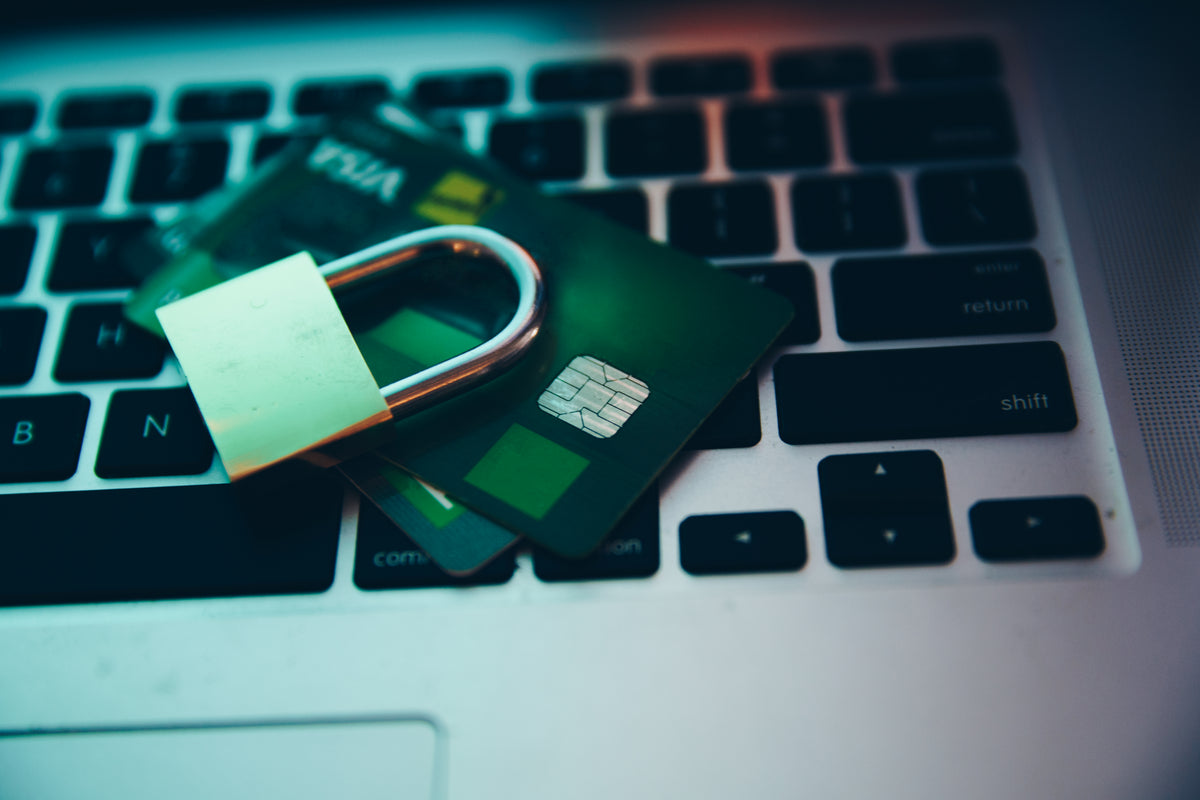 A padlock rests on a card placed over a laptop keyboard.