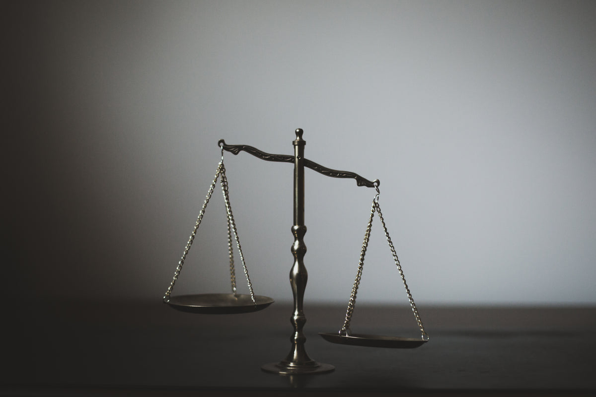 Antique balance scales rest on a dark tabletop.