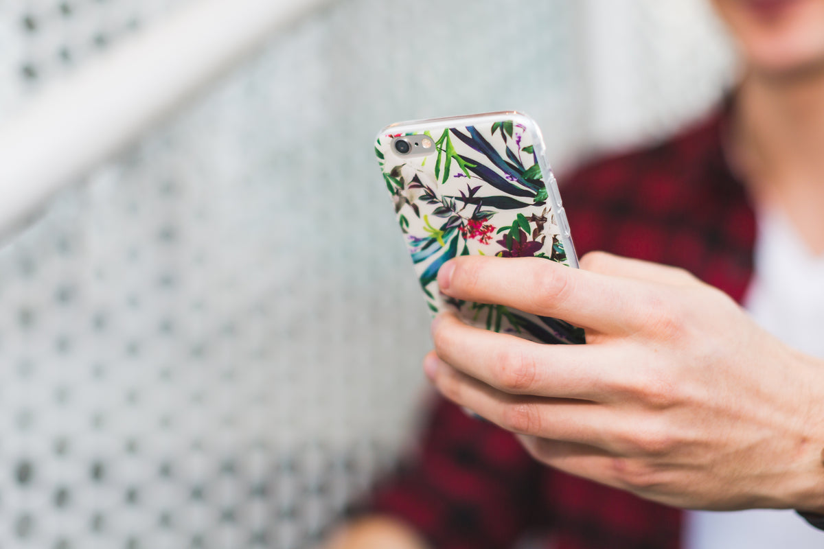 Close-up of a person holding a floral phone case.