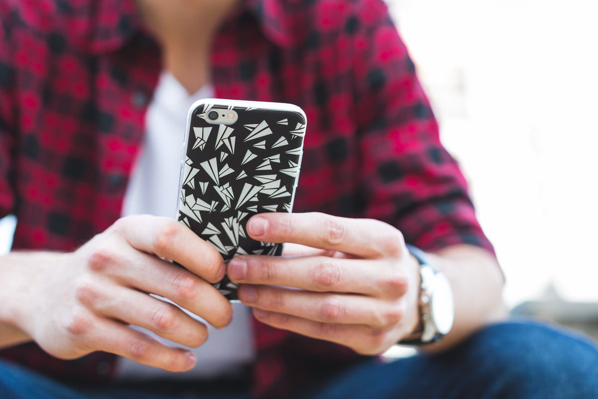 Close-up of hands holding a patterned smartphone.